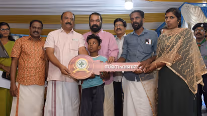 Ministers V Sivankutty and KN Balagopal handing over house keys to Midhun's parents in West Kallada