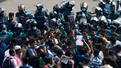 Protesters injured in the July uprising block a road at Shahbagh Square in Dhaka