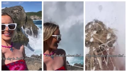 young woman gets caught in the waves while taking a selfie