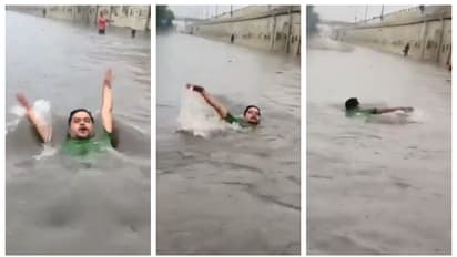 man swims through waterloagged road in delhi after heavy rain 