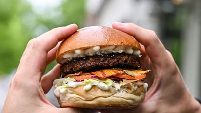The vegetarian burger "Tiergarten Burger" is held in the hands of a man in Berlin's Hard Rock Cafe.
