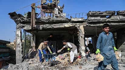 Afghan workers remove debris from a house, which was damaged after an air strike during cross-border clashes between Afghanistan and Pakistan, in Kabul on October 16, 2025.