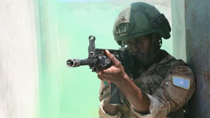 A Somali soldier aims a weapon during military training.