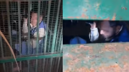 man trapped in metal cage intended to catch leopard