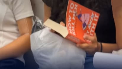 Woman Reading Controversial Book on Metro