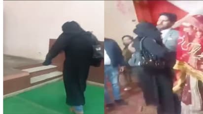 Burqa veiled person hugging groom