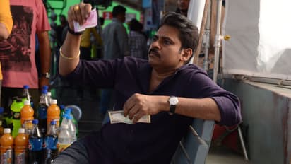 కొత్త రెండు వేల రూపాయల నోటును పాత వందతో పోల్చి పరిశీలిస్తున్న పవన్ కళ్యాణ్