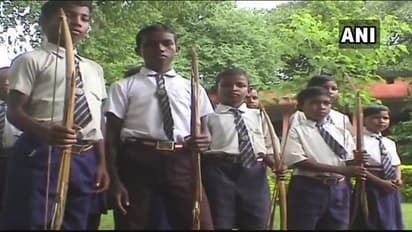 झारखंड में तीर-कमानों से साए में पढ़ने जाते बच्चे