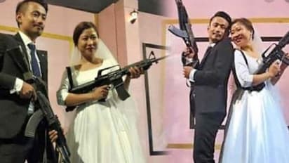 വിവാഹവേദിയിൽ എകെ 56 തോക്കുമായി ഫോട്ടോയ്ക്ക് പോസ് ചെയ്ത് വധൂവരന്മാർ