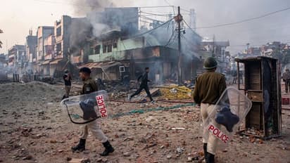 দিল্লি হিংসায় রাজধানীতে কড়া নিরাপত্তা আটক বন্দুক উঁচিয়ে যাওয়া যুবক