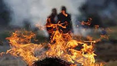 కరోనాతో భర్త మృతి... చితికి నిప్పు పెట్టిన భార్య