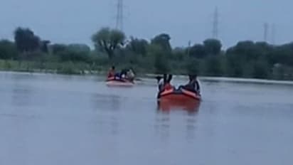 బైక్తో సహా వరదలో కొట్టుకుపోయిన యువకులు: కాపాడిన మత్స్యకారులు, చివరికిలా....