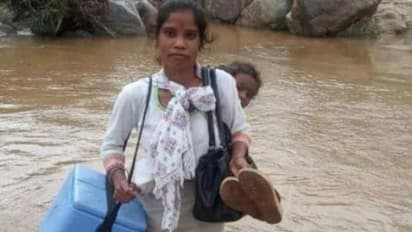 പിഞ്ചുകുഞ്ഞിനെ തോളിൽ കിടത്തി, വാക്സിൻ പെട്ടിയുമായി പുഴമുറിച്ച് കടക്കുന്ന ആരോഗ്യപ്രവർത്തക