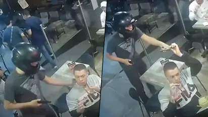 Man Quietly Eats Chicken Wings During Armed Thief Robs Restaurant; Watch Viral Video
