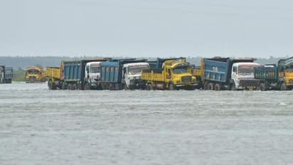 కృష్ణా నదిలో చిక్కుకున్న 132 లారీలు: క్రేన్ల సహాయంతో బయటకు
