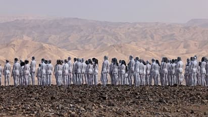 ന​ഗ്നരായി, ശരീരത്തിൽ വെളുത്ത ചായം പൂശി, കൈകൾ താഴ്ത്തി, പത്ത് വരികളിലായി അവർ നിന്നു...