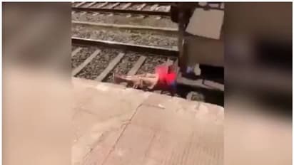 റെയിൽ പാളത്തിന് നടുവിൽ കിടന്ന് യുവതി, മുകളിലൂടെ കുതിച്ച് പാഞ്ഞ് ട്രെയിൻ, കൂസലില്ലാതെ ഫോൺവിളിച്ച് മടക്കം-വീഡിയോ