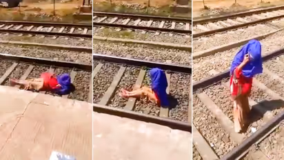 Watch: Woman talks on phone as train passes over her; netizens outraged