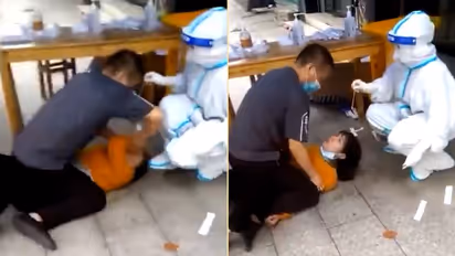 Watch:Chinese woman pinned down on floor for forced Covid-19 test