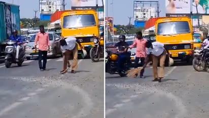 Watch: Traffic cops sweep away trap rocks from road for commuters