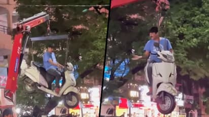 Man casually sits on hanging scooter while traffic police towed it; dramatic video goes viral