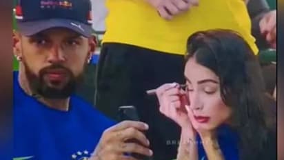 സ്റ്റേഡിയത്തിൽ കളി കാണുന്നതിനിടെ ഭാര്യയെ മേക്കപ്പിടാൻ സഹായിക്കുന്ന ഭർത്താവ്; വൈറലായി വീഡിയോ 