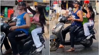 പൊതുവഴി, സ്വയം കുളിച്ചും യുവാവിനെ കുളിപ്പിച്ചും യുവതി, സ്കൂട്ടറിൽ അഭ്യാസം; 'പണി പാളി', പ്രതികരിച്ച് പൊലീസ്