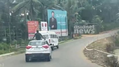 കാറിന് മുകളിലിരുന്ന് യുവാവിന്റെ യാത്ര, ദൃശ്യം പകര്ത്തിയവര്ക്ക് ഭീഷണി; കാറുടമ എംവിഡിക്ക് മുന്നിൽ ഹാജരായേക്കും