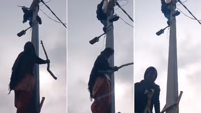 UP woman climbs electric pole to confront lineman over power cut, forces him to back down (WATCH)
