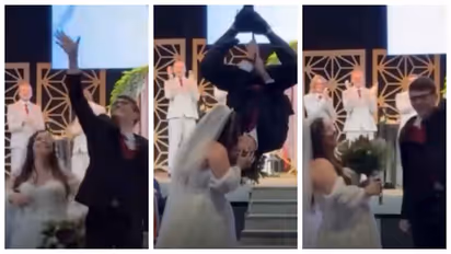 Groom climbs a rope to kiss his bride in spiderman style