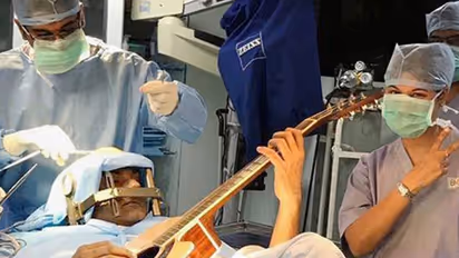 Doctor conducts surgery while the patient played guitar