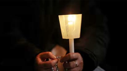 A nun holds a candle and a rosary during a prayer service in St. Peter's Square, as Pope Francis continues his hospitalization, at the Vatican (Image/Reuters)