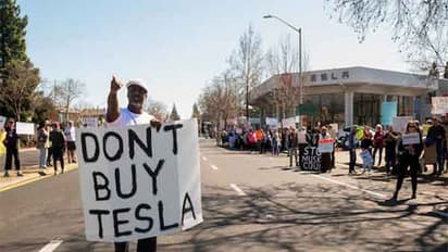 People protest against Tesla and Elon Musk outside of a Tesla dealership in Palo Alto, California (Image/Reuters)