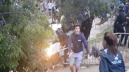 A person held by police personnel in riot gear after a car drove into the crowd near the RCDE Stadium in Barcelona (Image Credit: Reuters)