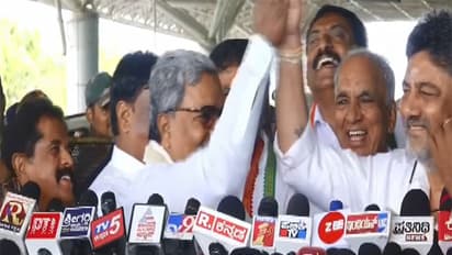 Karantaka CM Siddaramaiah holds deputy CM DK Shivakumar's hand in delight (Photo: ANI)