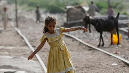 A girl balances herself while walking on an abandoned railway track in a slum area in Karachi (Image/Reuters)