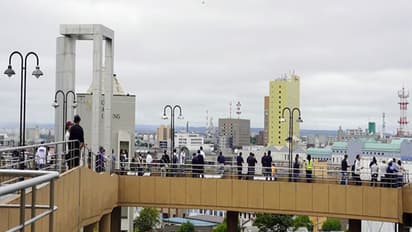 People look on after being evacuated to a temporary tsunami evacuation site in Japan (Image/Reuters)