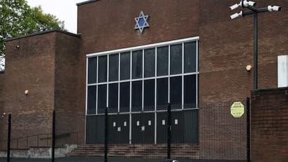 A man looks at floral tributes outside the Manchester synagogue, where multiple people were killed on Yom Kippur (Photo/Reuters)