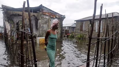 A woman stands outside her home after heavy rains from the outer bands of Hurricane Melissa flooded parts of Les Cayes, Haiti (Photo/Reuters)