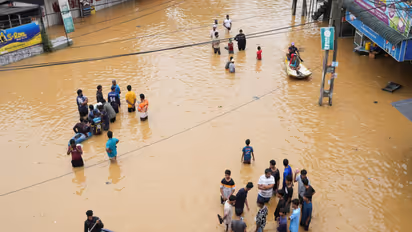 People use boats to move on a flooded street as others stand around, following heavy rainfall in Malwana, Sri Lanka (Photo/Reuters)