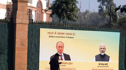 A man walks past a hoarding installed to welcome Russia's President Vladimir Putin to India on his visit, outside Hyderabad House, in New Delhi on Thursday. (Photo/ANI)