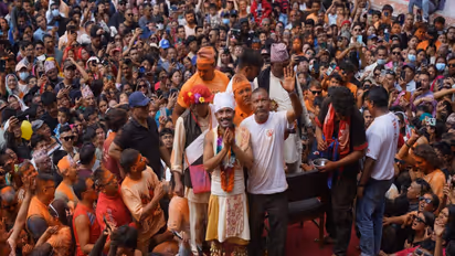 Devotee Sujan Bagh Shrestha stands on a platform amid a large crowd after performing the tongue-piercing ritual during Jibro Chedne Jatra in Bode, Bhaktapur. (Photo/ANI)