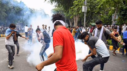 Protestors cover their face as security personnel fire tear gas shells on them during their protest march towards Parliament (File Photo/ANI)