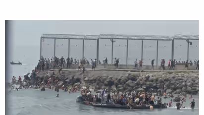 Migrants gather on and around a Guardia Civil boat as they swim through Spain's Ceuta border from the Moroccan side (Photo/ANI)