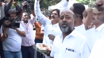 Supporters of Karnataka Deputy Chief Minister DK Shivakumar distribute sweets outside his residence (Photo/ANI)