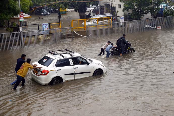 गुजरात: कहीं बाढ़ में फंसी 8 महीने की गर्भवती तो कहीं छत पर शरण लेने को मजबूर रहवासी, 8 PHOTO में बारिश का कहर