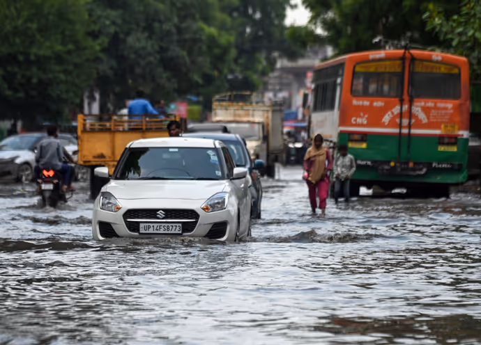 दिल्ली NCR-गाजियाबाद में बारिश की 10 तस्वीरें: बच्ची को पानी से बचाती दिखी मां तो कहीं जान जोखिम में डाल निकले लोग