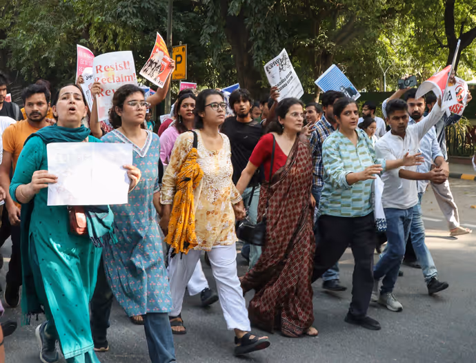 दिल्ली पुलिस के नेहा बोरा को घसीटते ले जाने की 5 तस्वीरें, चेहरे पर मुस्कान बरकरार