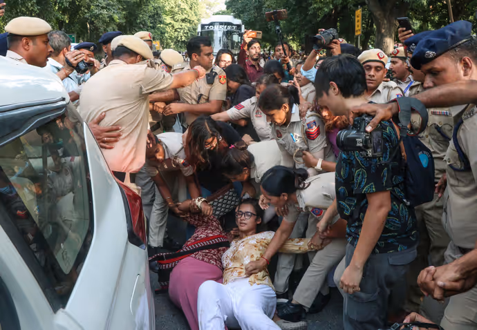 दिल्ली पुलिस के नेहा बोरा को घसीटते ले जाने की 5 तस्वीरें, चेहरे पर मुस्कान बरकरार