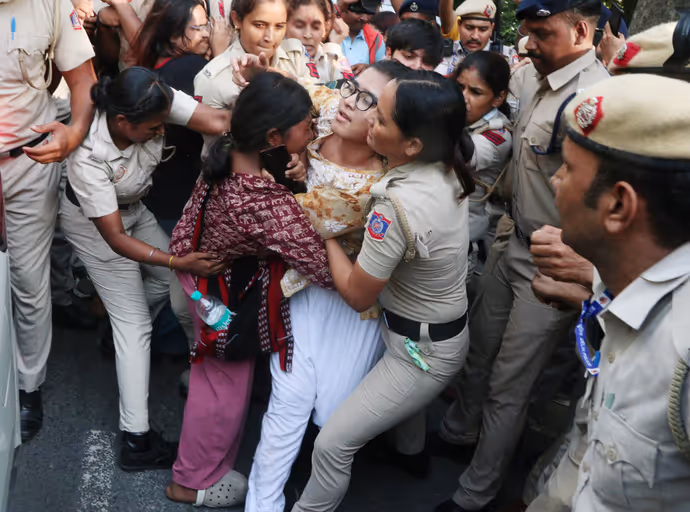 दिल्ली पुलिस के नेहा बोरा को घसीटते ले जाने की 5 तस्वीरें, चेहरे पर मुस्कान बरकरार